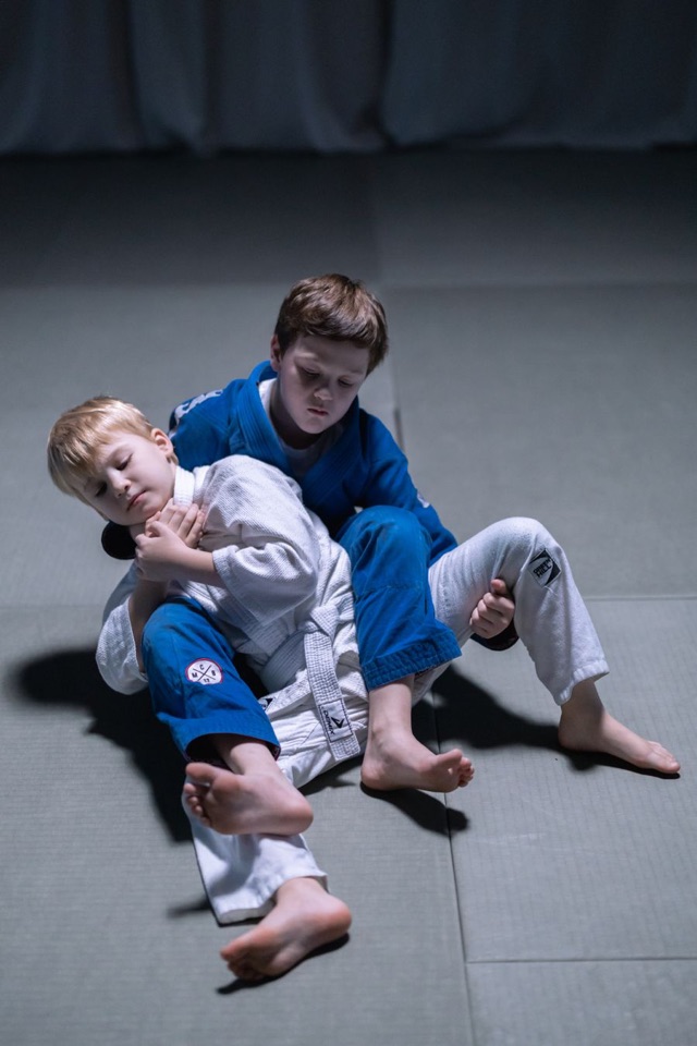 Zwei Kinder im Judogi üben gemeinsam eine Bodentechnik (Ne-waza)